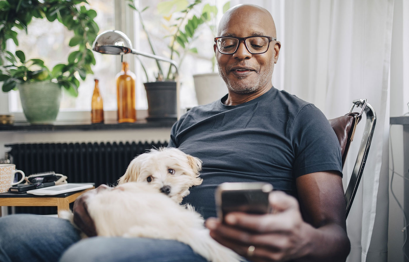 man with a dog looking at his mobile phone